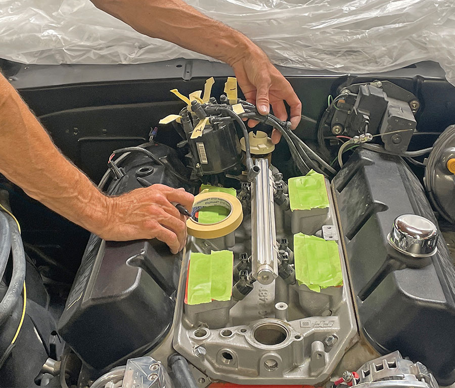 Close-up of distributor with marked ignition wires for identification.
