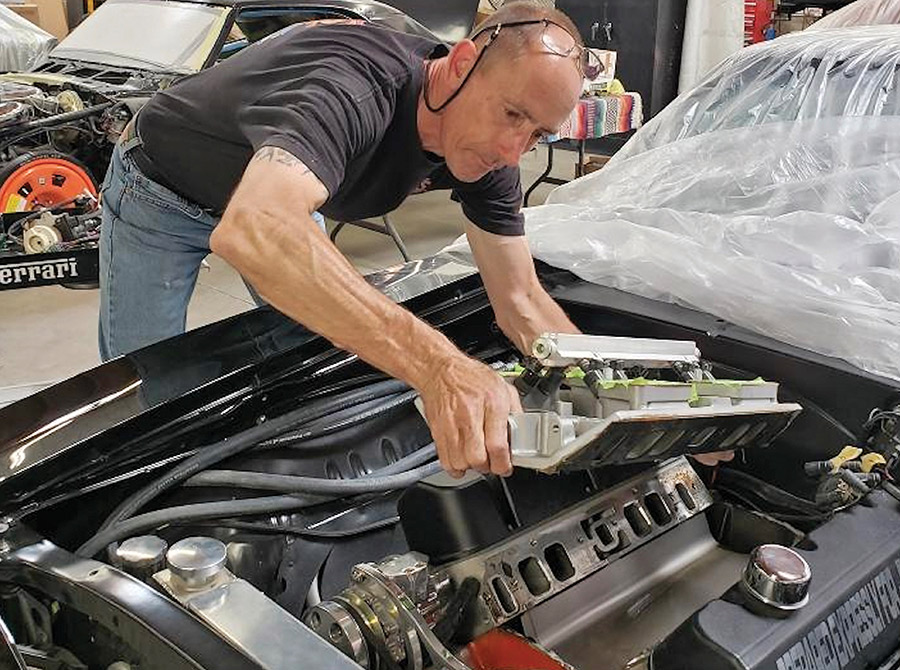 Lifting the intake manifold clear of the engine.