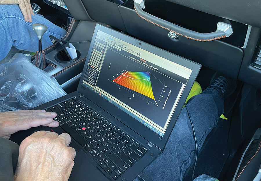 Laptop screen displaying a 3D fuel map tuning graph.