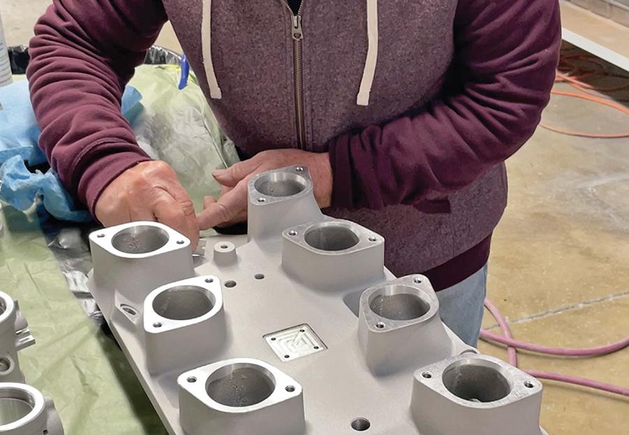 Prepping the intake manifold for paint by removing rough casting edges.