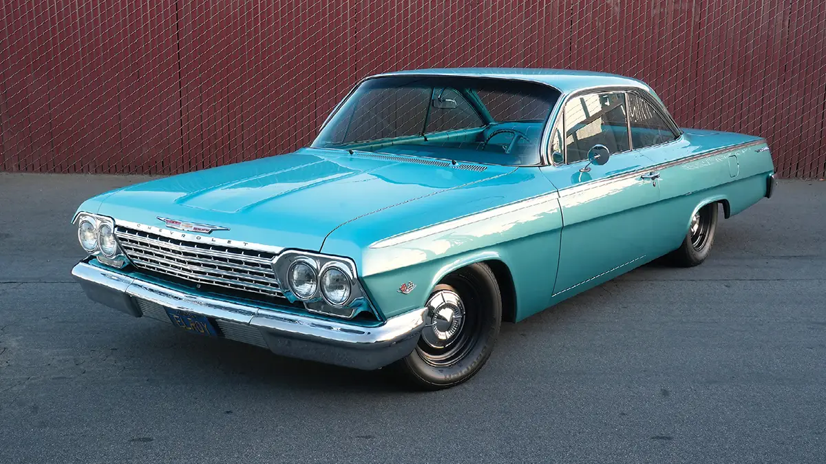 High-angle front three-quarter view of a turquoise 1962 Chevy bubbletop.