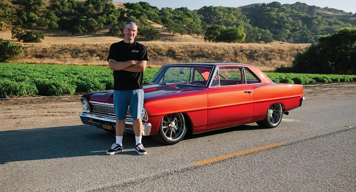 Owner Chris Corona standing next to his red Nova.